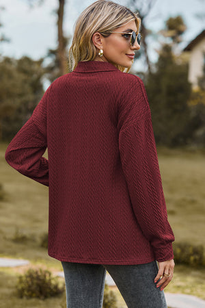 Burgundy textured polo-neck sweater with button detail and long sleeves.