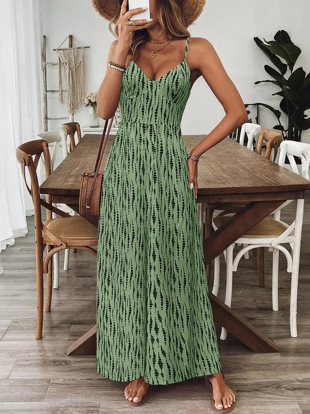 Matcha green wide-leg jumpsuit with black abstract print, spaghetti straps, and V-neck.
