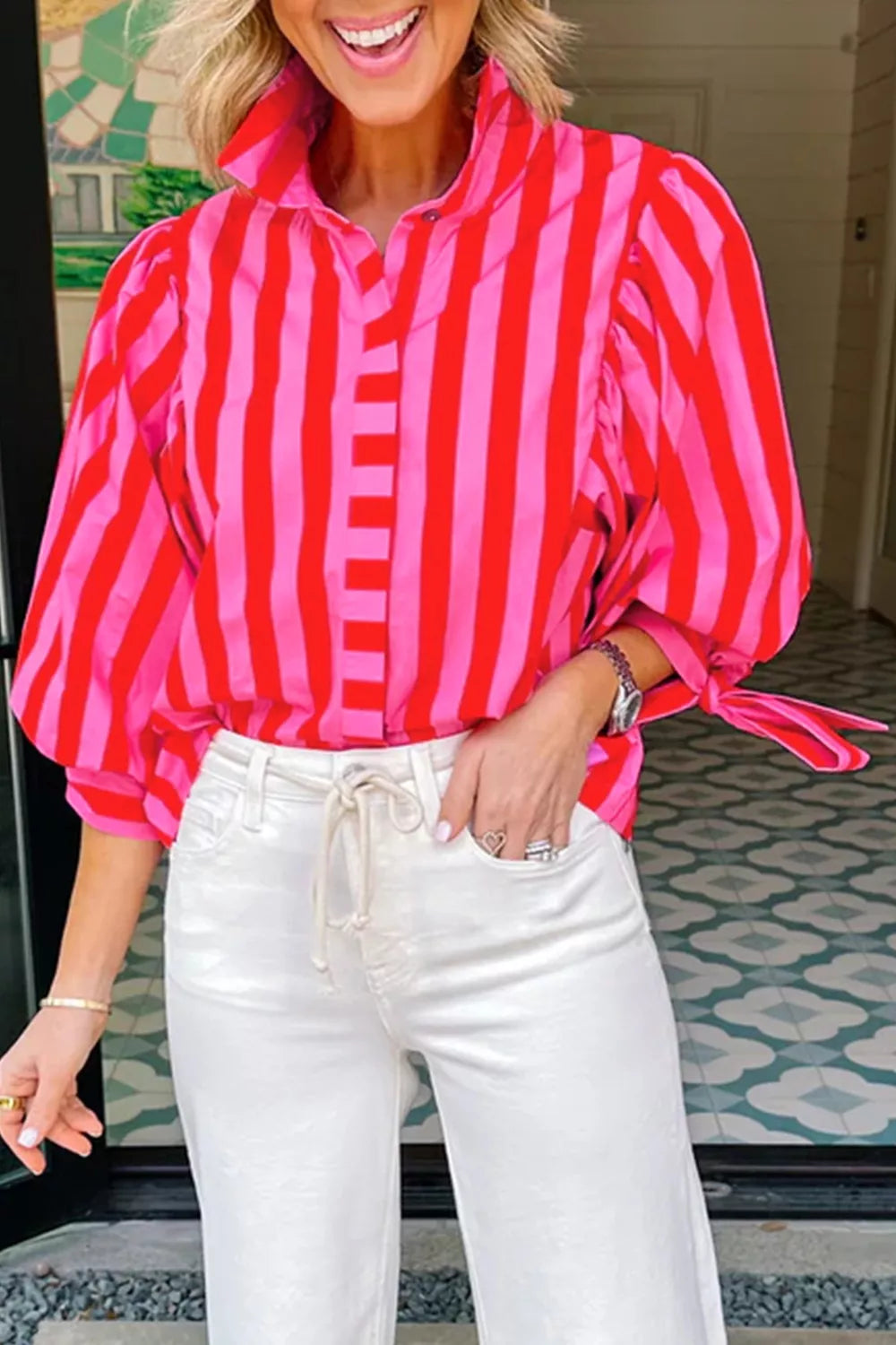 Vibrant puff sleeve button-down shirt in pink and red stripes with tie cuffs.