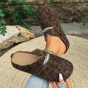 Brown leopard print slip-on flats with chain detail and metal buckle.