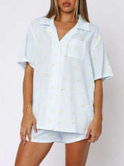 Light blue striped pajama set with yellow floral print, collared button-up shirt and shorts.