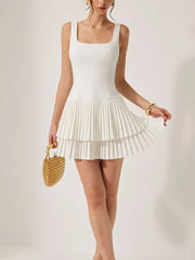 White square neck mini dress with tiered pleated skirt and sleeveless design.