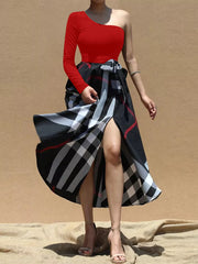 Red one-sleeve asymmetrical midi dress with belted plaid skirt and high slit.