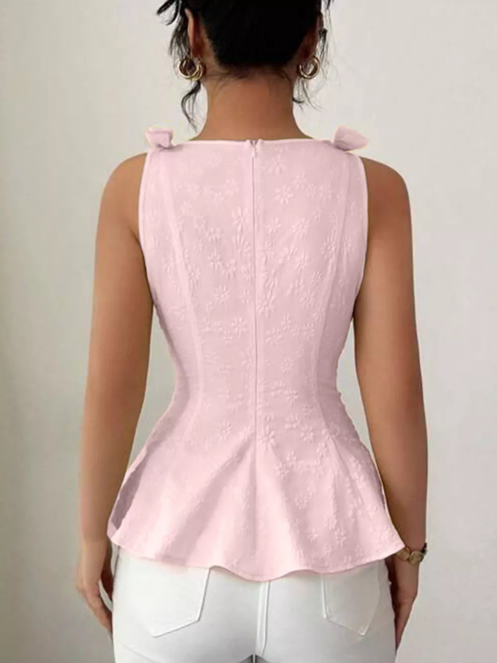 Pink peplum tank top with floral embroidery and bow shoulder details