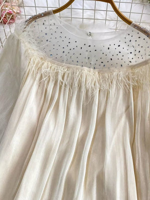 Apricot sheer mesh blouse with rhinestone-embellished neckline and feather trim.
