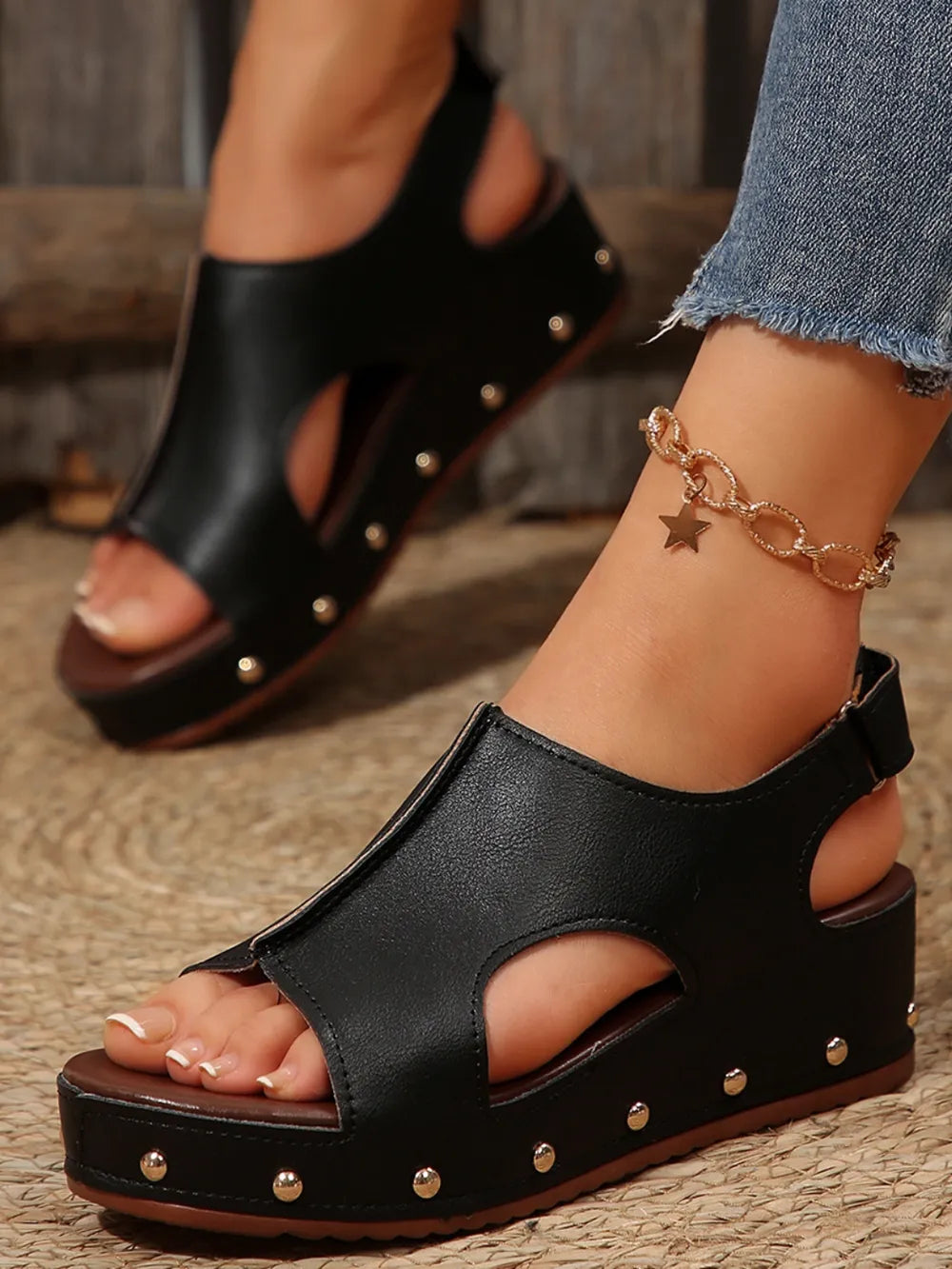 Black cutout studded platform sandals with peep toe and ankle strap.