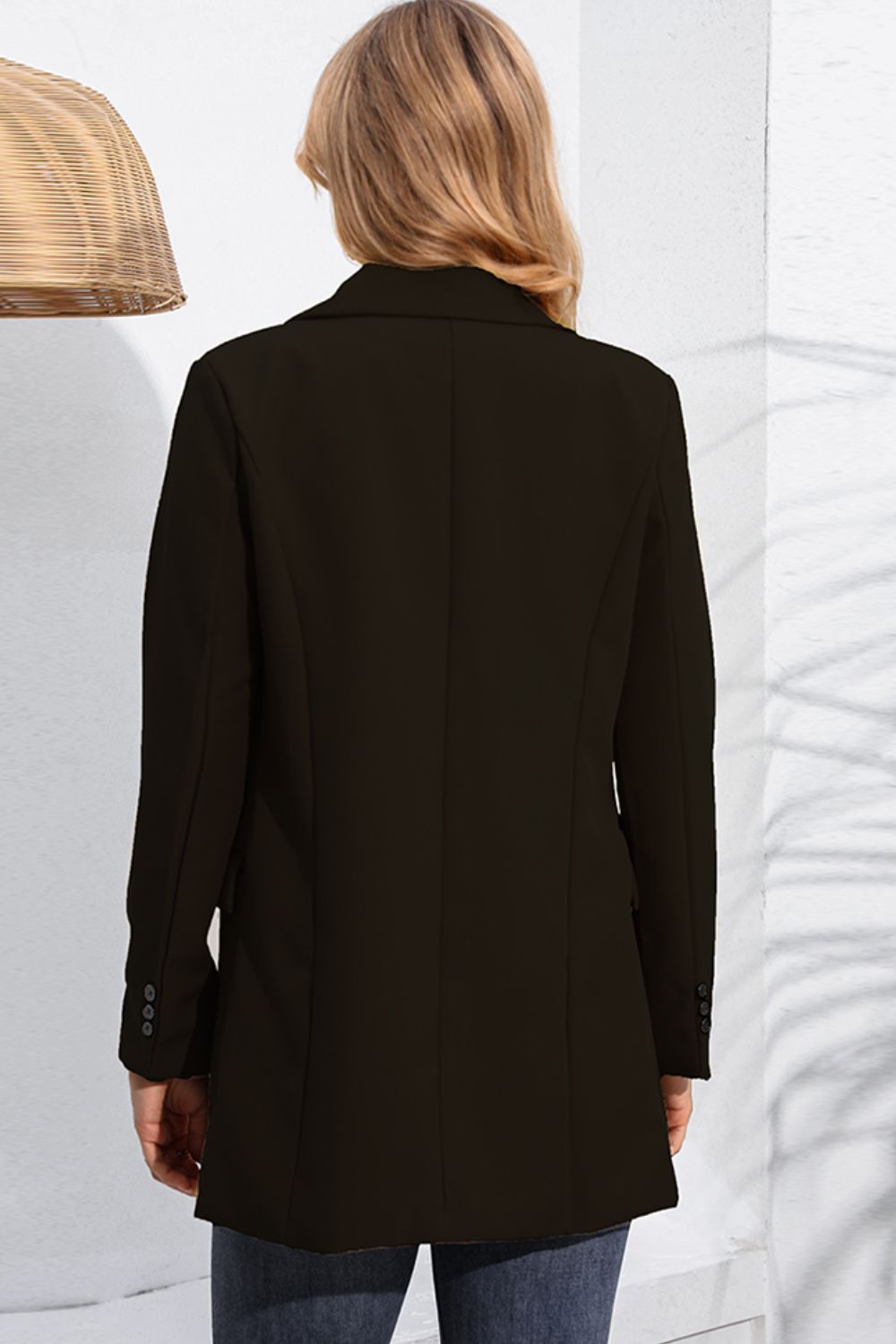 Black double-breasted tailored blazer with flap pockets and button cuff detail.