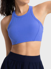Blue ribbed racerback crop top with contour stitching and a high neckline.