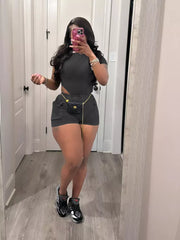 Black ribbed crop top and shorts set with pockets and chain belt detail.