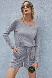 Gray jersey pocket romper with long sleeves, drawstring waist, and shorts.