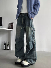 Relaxed fit blue denim cargo jeans with drawstring waist and zippered pockets.
