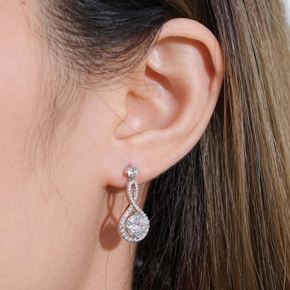 Infinity drop earrings with clear stones and a white metal setting.