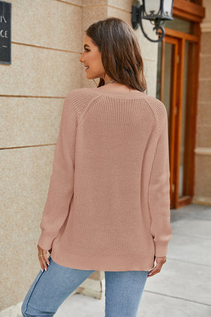 Coral relaxed V-neck raglan knit sweater with a textured stitch.