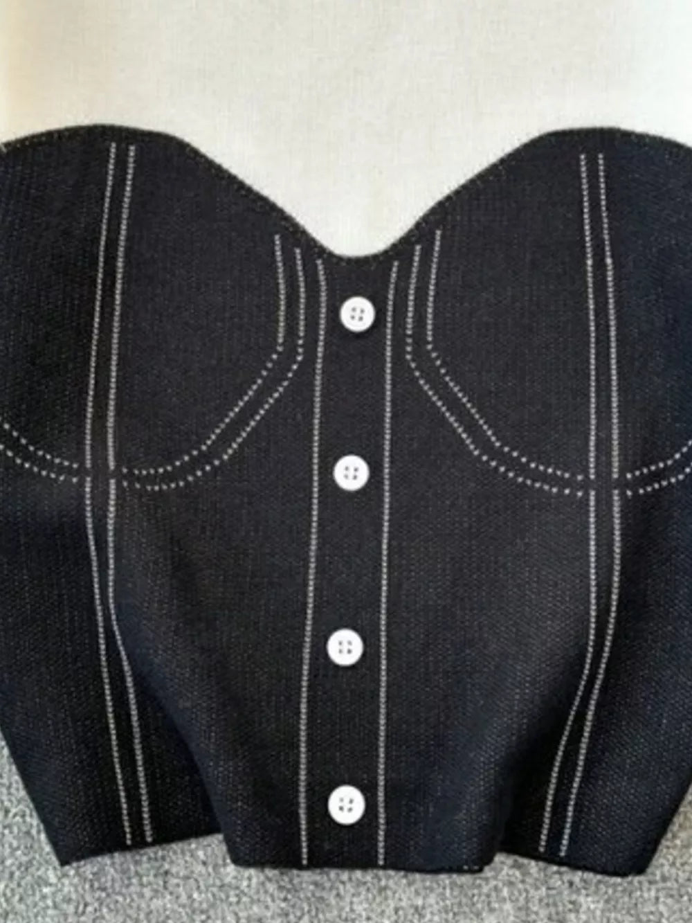 Color block knit t-shirt in black with white buttons and ribbed detail.