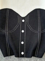 Color block knit t-shirt in black with white buttons and ribbed detail.