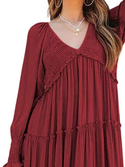 Wine red smocked v-neck tiered maxi dress with ruffled details and long sleeves.