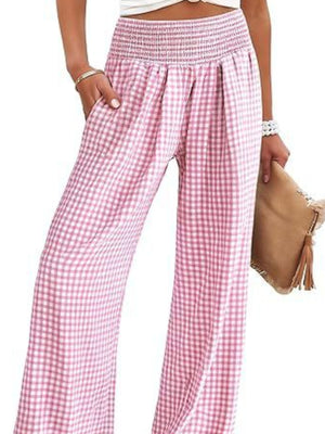 Smocked high-waist wide-leg pants in blush pink gingham with pockets.