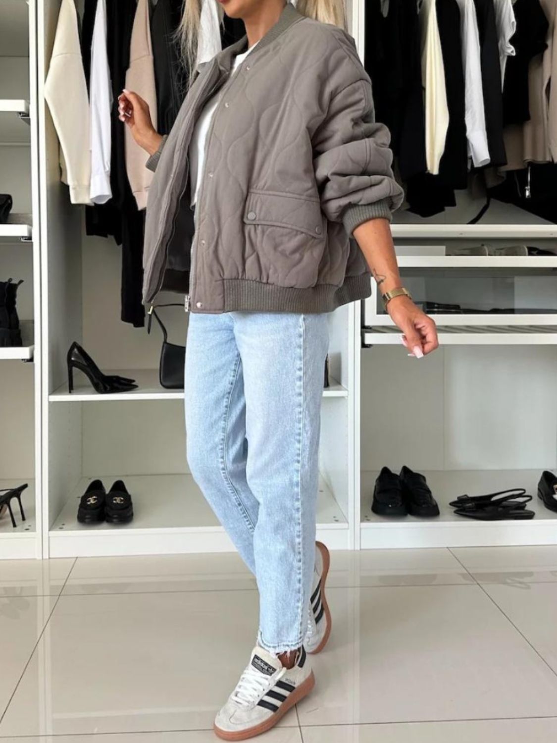 Quilted bomber jacket in taupe with rounded sleeves and front pockets.