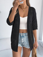 Black openwork knit duster cardigan with elbow-length sleeves, styled open over a white tank top and denim shorts.