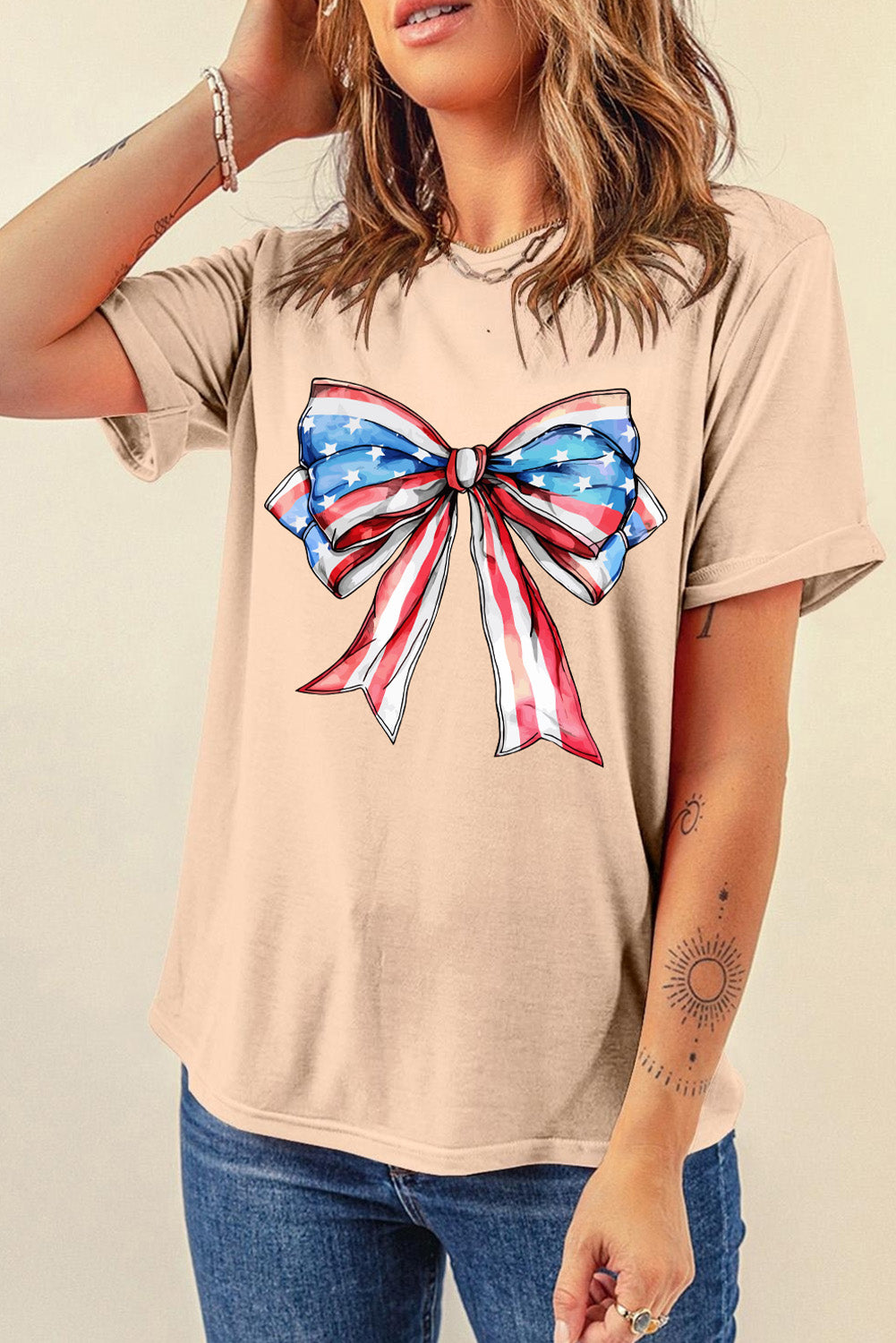 Eggshell t-shirt with a red, white, and blue bow graphic featuring stars and stripes.
