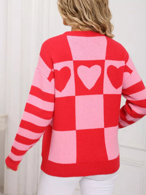 Red and blush pink checkerboard knit sweater with heart details and striped sleeves.