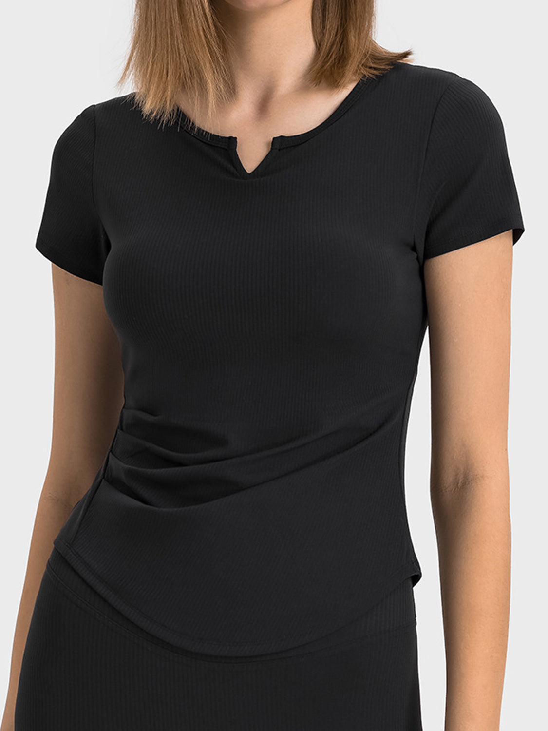 Black ribbed notch-neck active t-shirt with short sleeves and a sculpted fit.