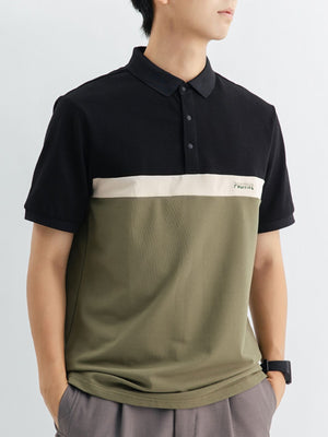 Men's color block polo shirt with black, beige, and olive green panels and embroidered text.
