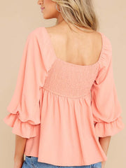 Watermelon pink babydoll blouse with square neckline, smocked back, and ruffled bell sleeves.
