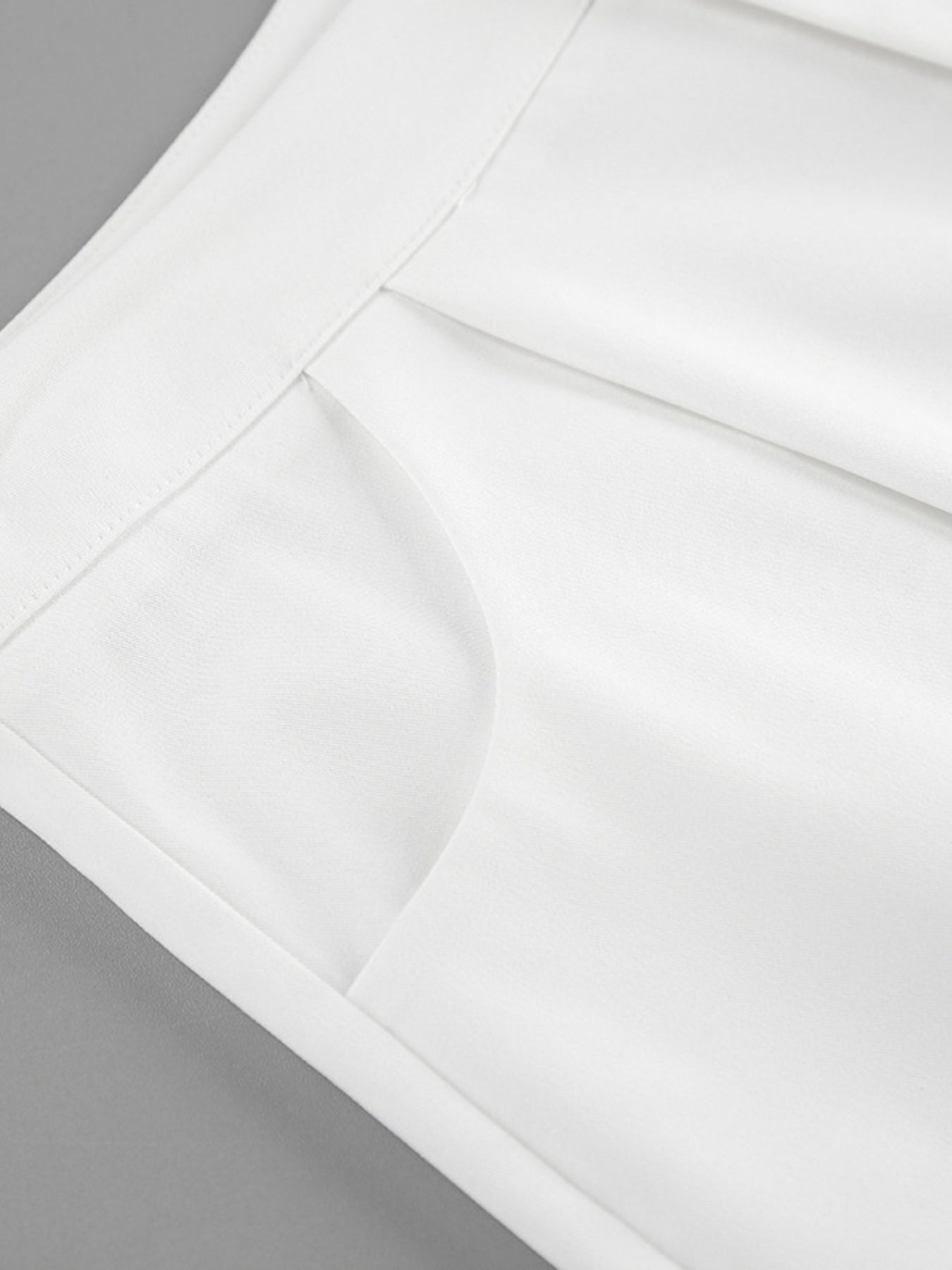 White two-piece set with snap details, featuring a pocket detail and crisp fabric.