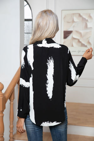 Black and white abstract brushstroke tie-front blouse with buttoned cuffs.