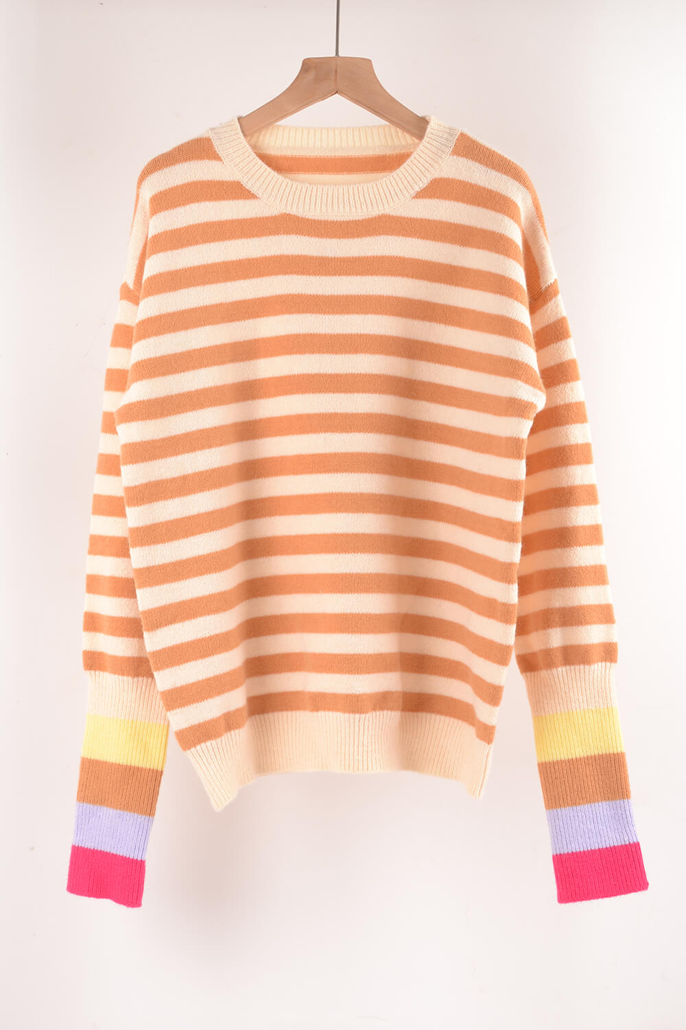 Acrylic sweater with orange and cream horizontal stripes and colorful striped cuffs.