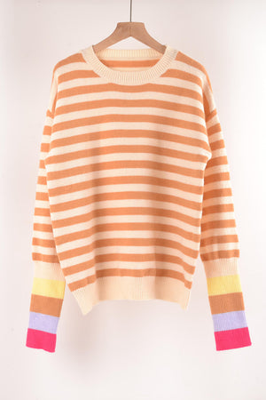 Acrylic sweater with orange and cream horizontal stripes and colorful striped cuffs.