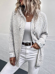 Textured knit zip-up cardigan in a herringbone pattern with a drawstring hood and logo detail on the sleeve.