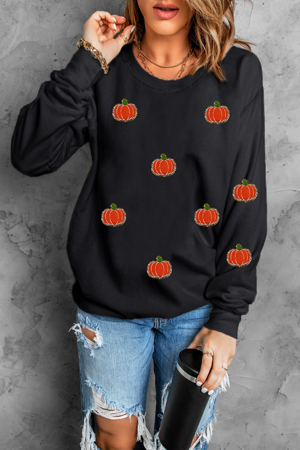 Black crewneck sweatshirt with allover embroidered pumpkin patches.