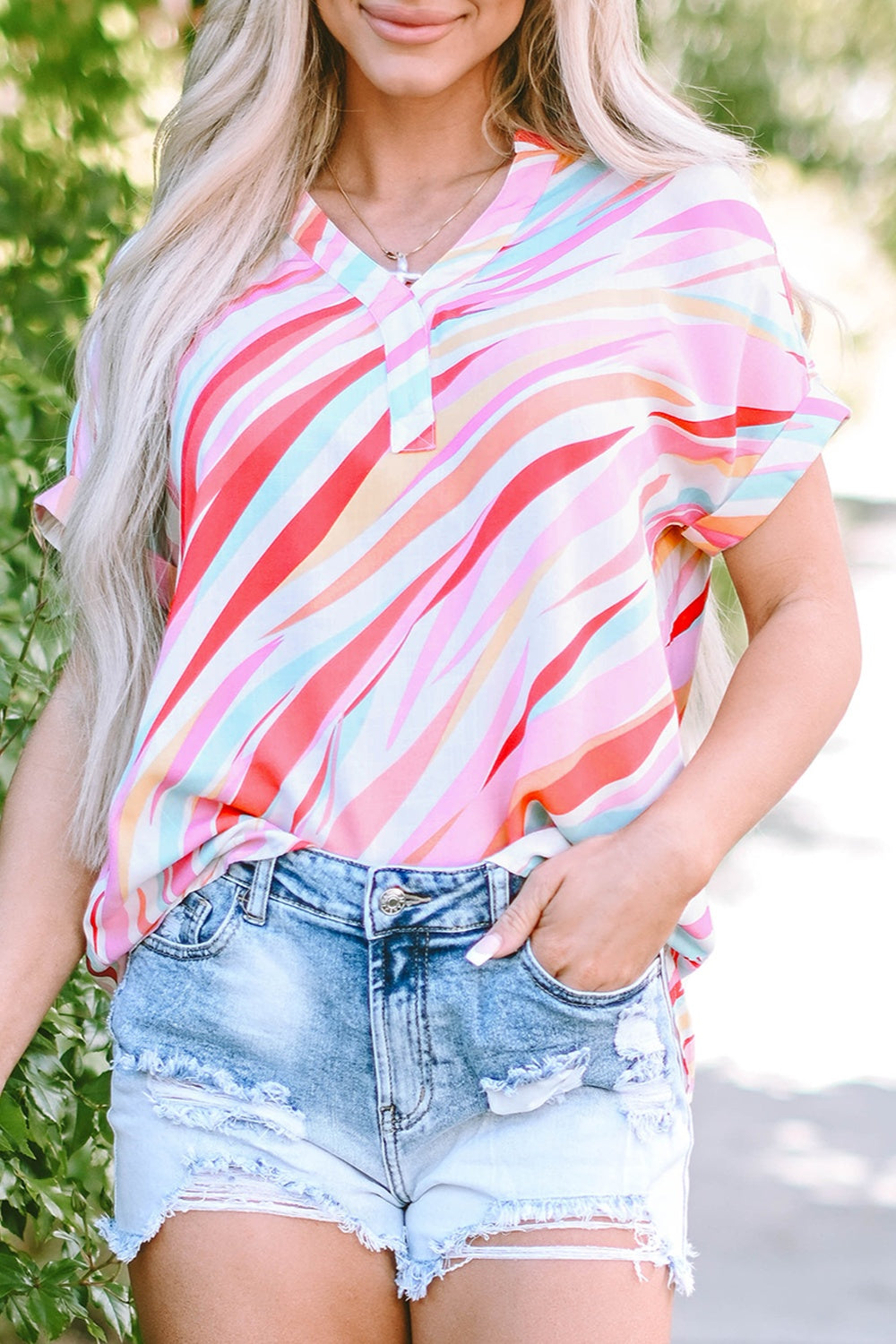 Prismatic stripe henley blouse in blush pink with a v-neck and short sleeves.