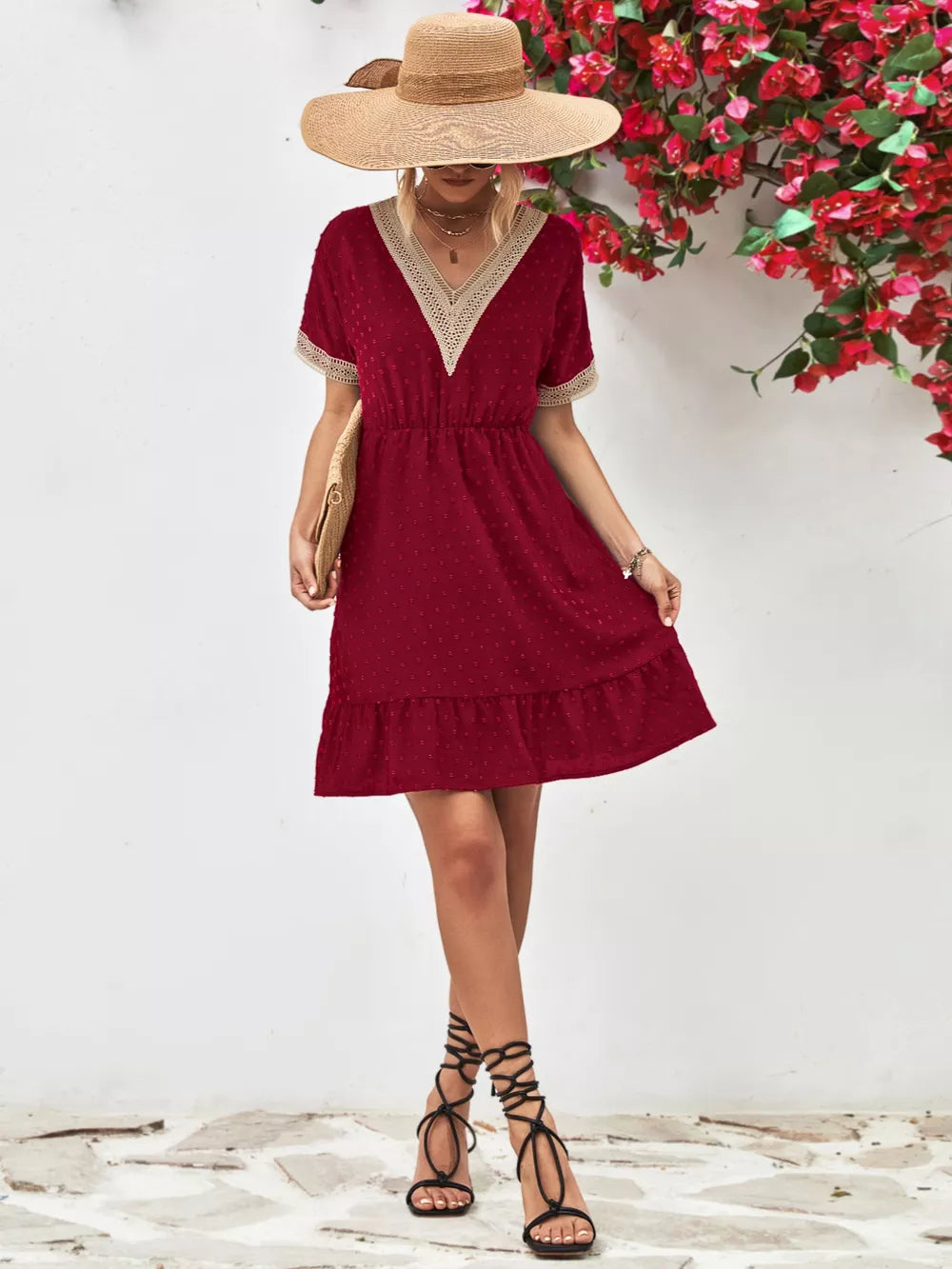 Burgundy Swiss dot mini dress with V-neck, lace trim, short sleeves, and tiered hem.