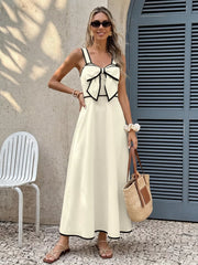 Elegant beige A-line midi dress with black trim and a large bow detail on the bust.