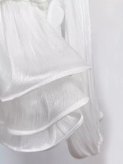 White ruffled mini dress with corset waist detail, sheer fabric.