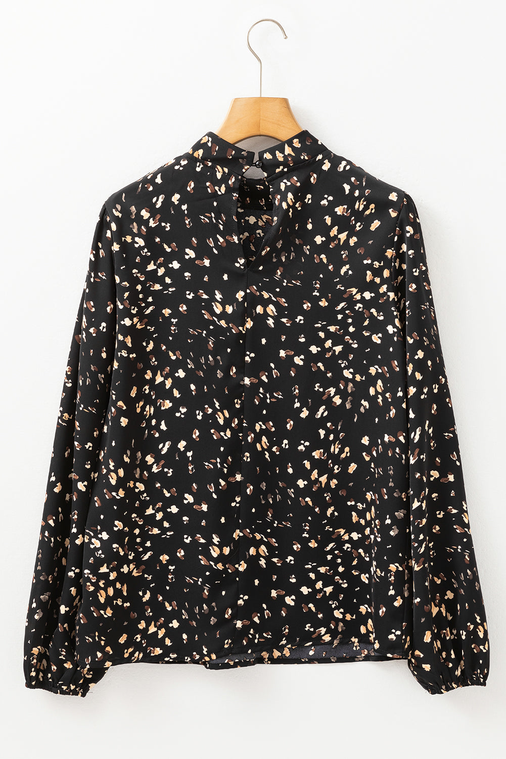 Black high-neck abstract print blouse with long sleeves and button closure at back neck.