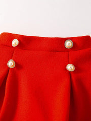 Red knit baby skirt with pearl and rhinestone buttons and pleats.