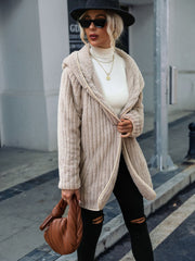 Sand textured teddy hooded open coat with cream trim, worn open over a white turtleneck.