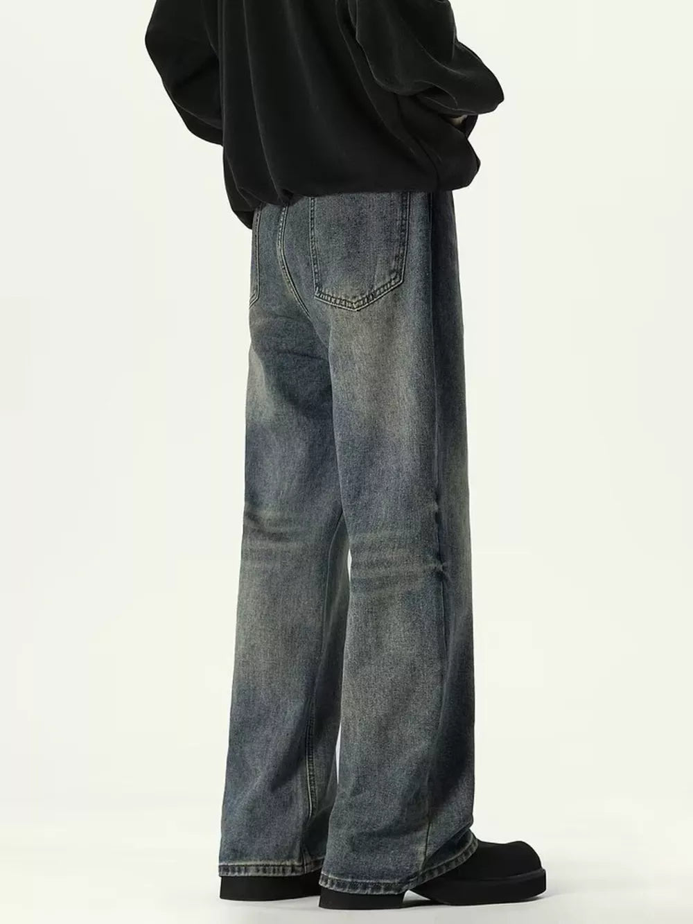 Men's relaxed fit denim jeans in a vintage wash with distressed details.