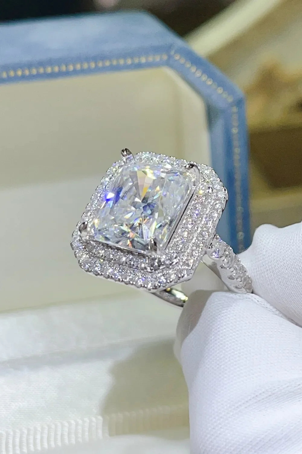 Radiant cut moissanite halo ring in silver with double halo and pavé band.