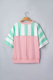 Oversized t-shirt with pastel stripes and pink ribbed panel, exposed seams.
