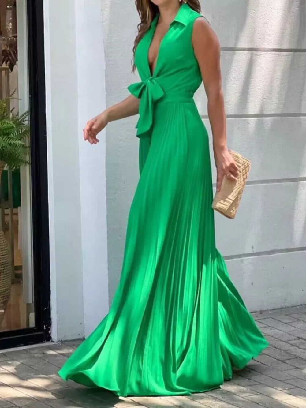 Green tie-front maxi dress with plunging neckline, sleeveless, and pleated skirt.
