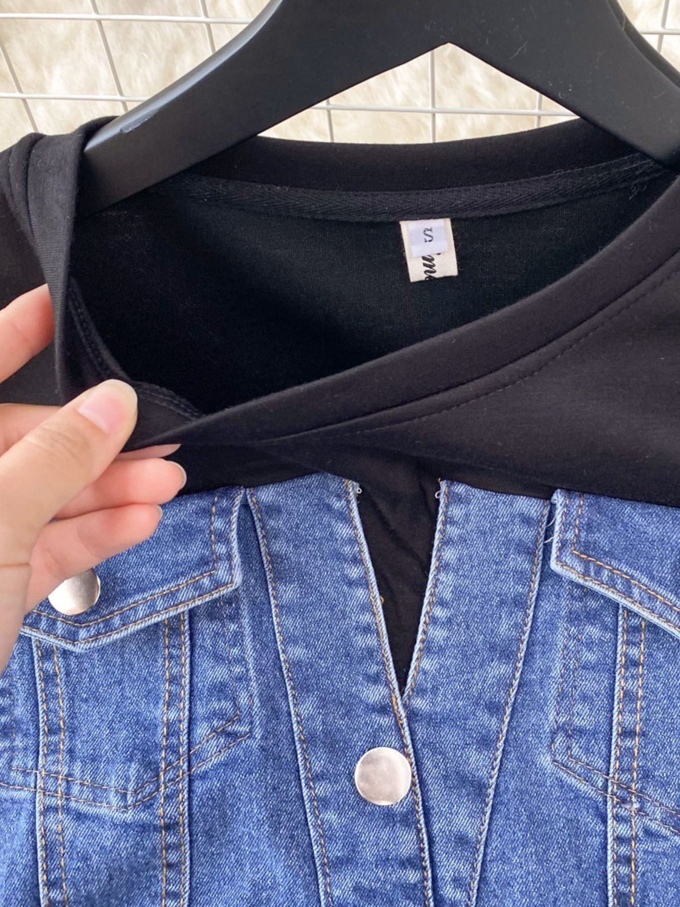 Denim patchwork short-sleeve dress with button details and a black top.