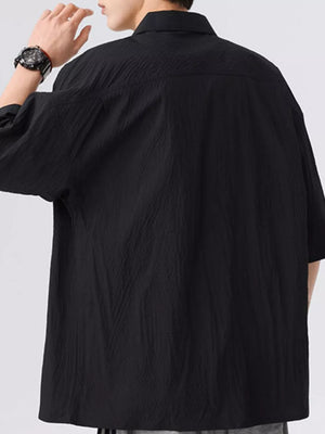 Black textured short-sleeve men's shirt with a buttoned collar.