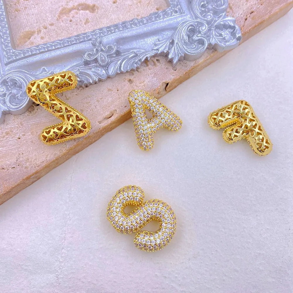 Gold bubble letter pendants with cubic zirconia and cut-out heart details