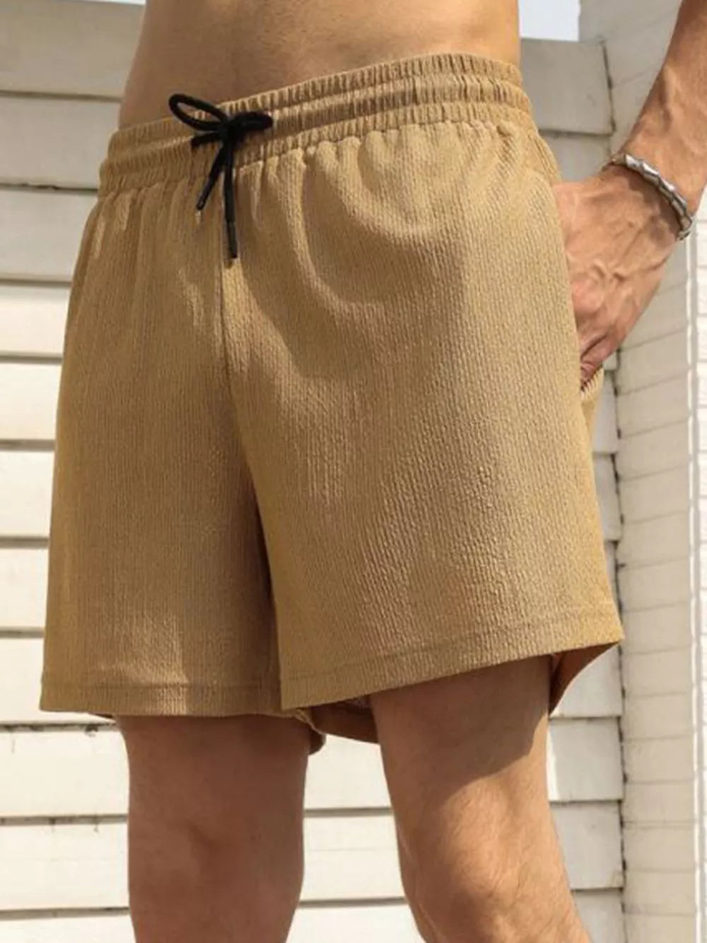 Men's khaki chino shorts with drawstring waist and textured fabric.