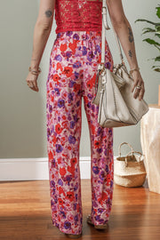 Painterly floral palazzo trousers in strawberry pink with a wide leg and elastic waist.